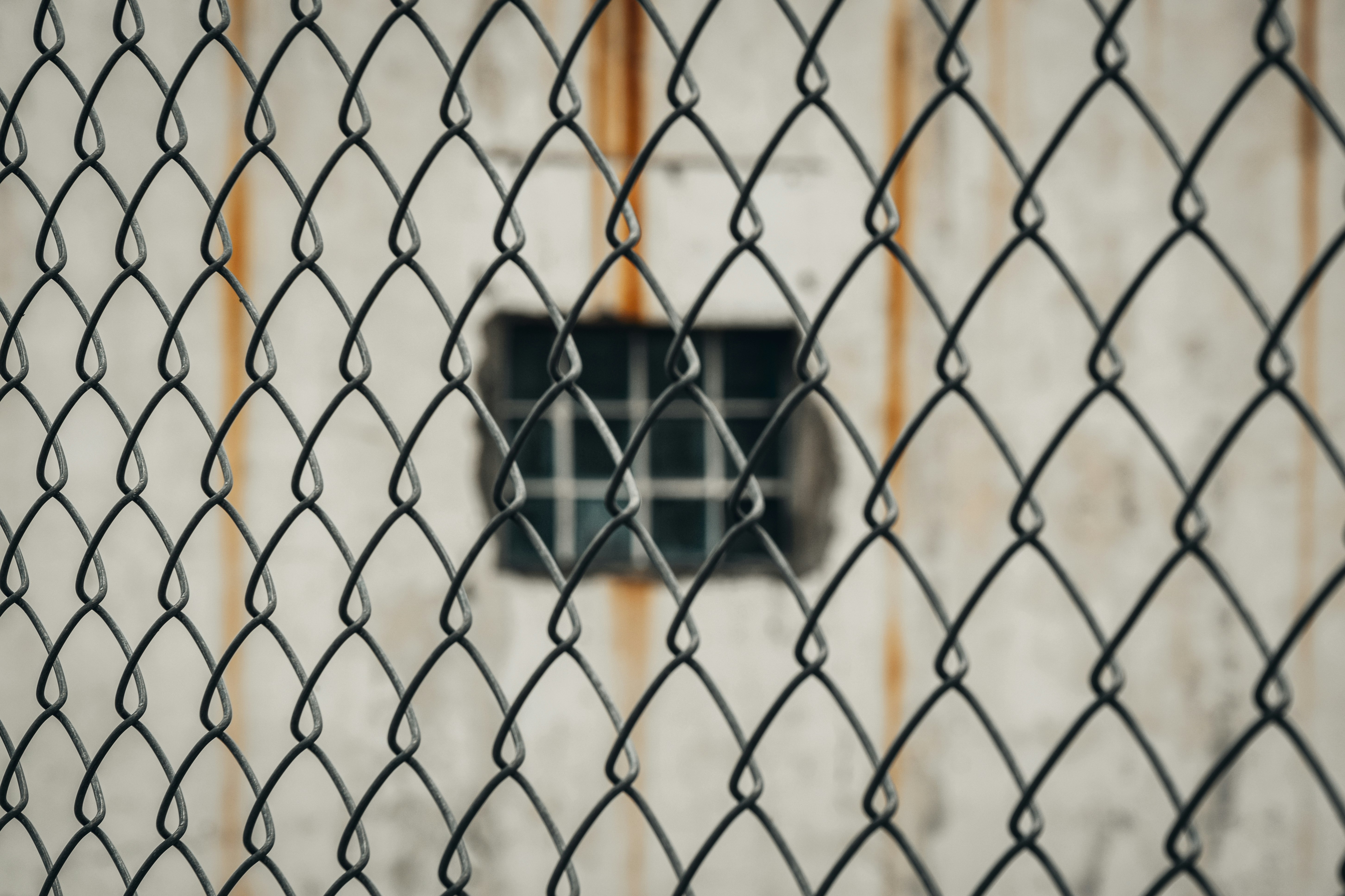 black and white square device on brown metal fence